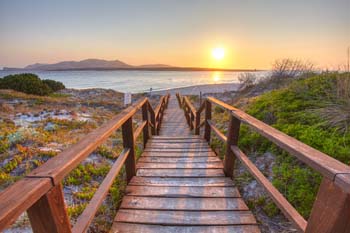 <b>Italy, Stintino</b>, Footbridge to La Pelosa beach at sunrise